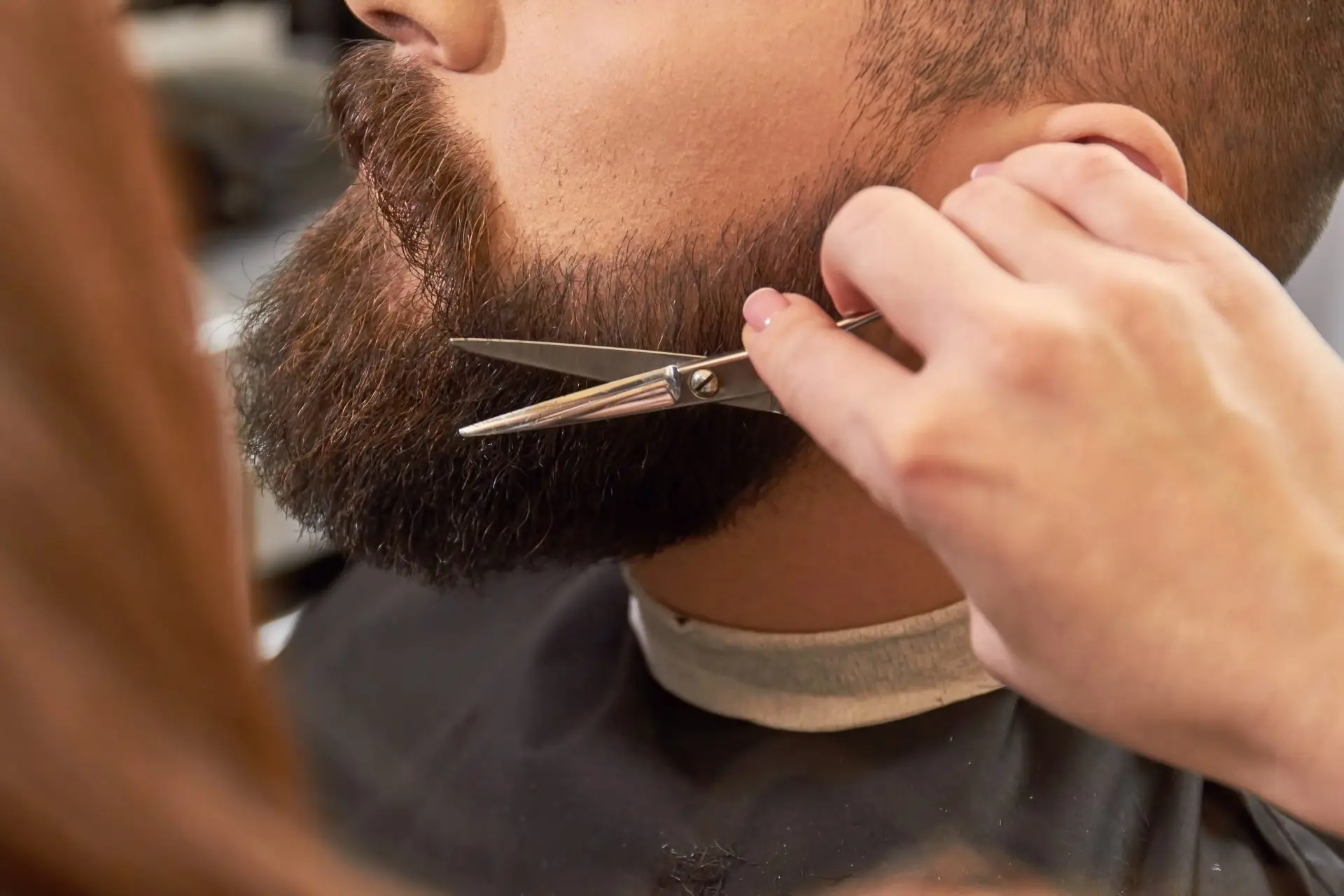 Barber trimming a beard with scissors Sharper Focus Ltd education talks Bristol